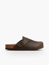 Zueco Genuins Riva  de piel engrasada color kaki con planta anatómica de caucho corcho y hebilla ajustable metálica para hombre en vista lateral  
